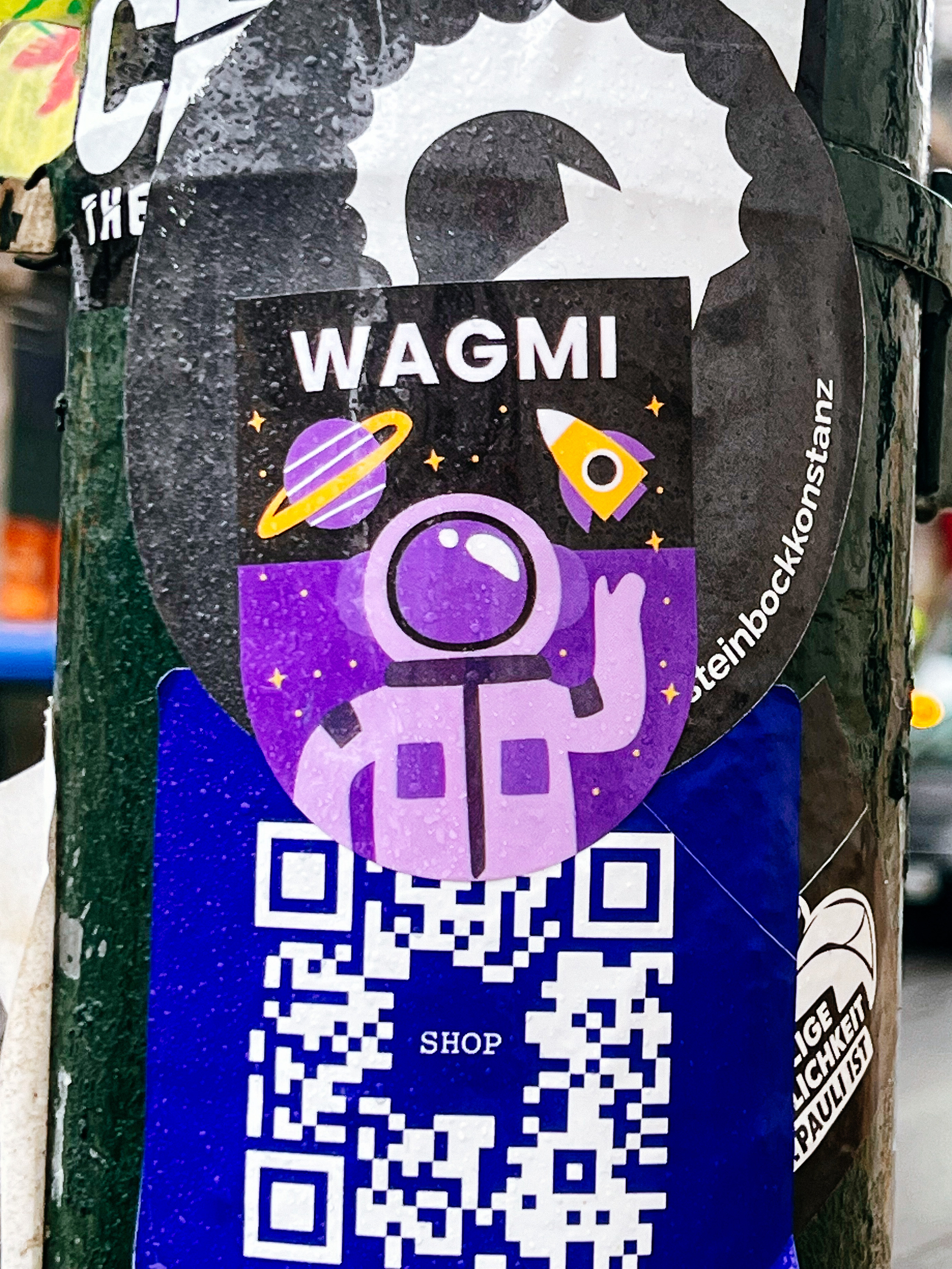 Sticker of a cute astronaut, with a rocket ship and a planet above him. It says “WAGMI” above the astronaut. 