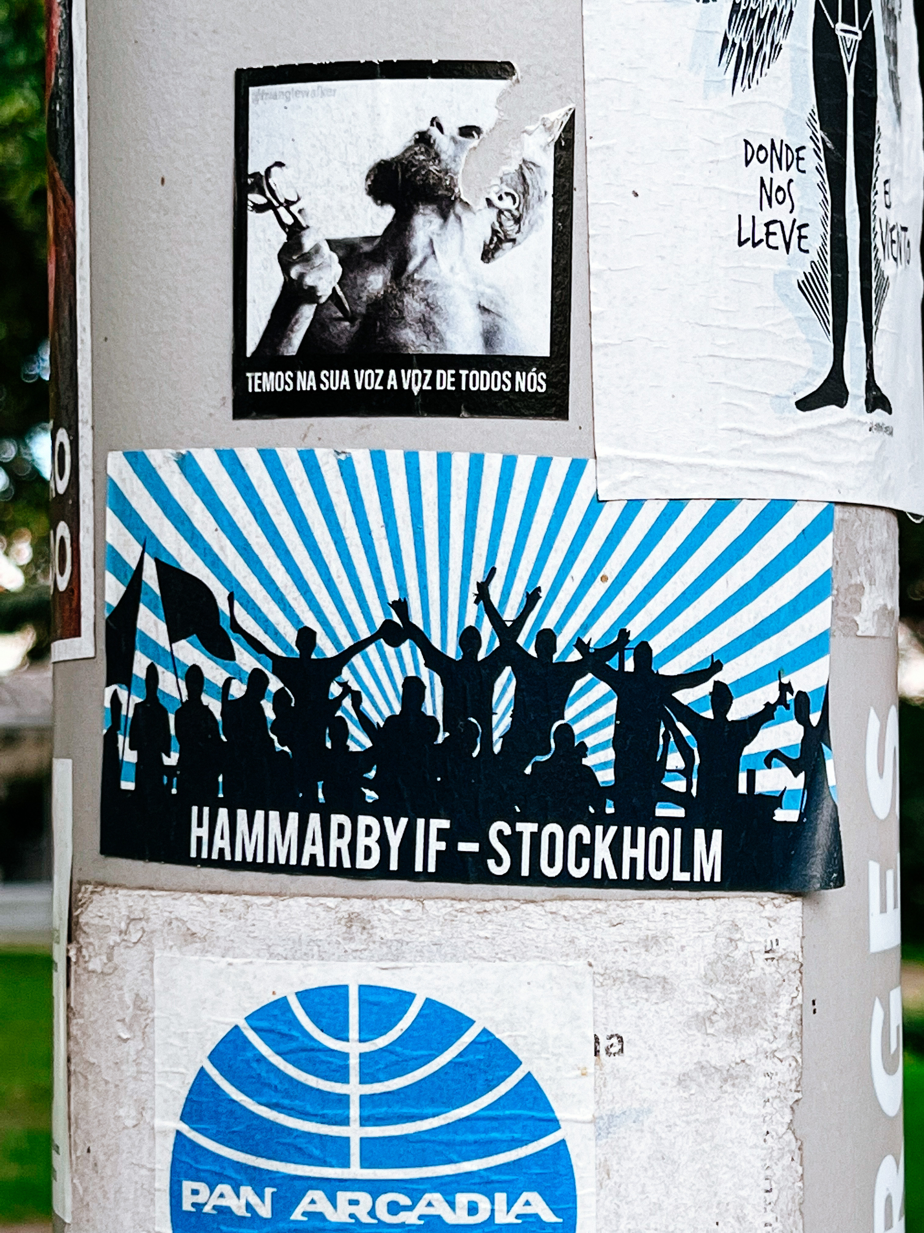 Sticker with an image of people standing up, waving their arms, blue rays behind them, and the words “HAMMARBY IF - STOCKHOLM” under it. 