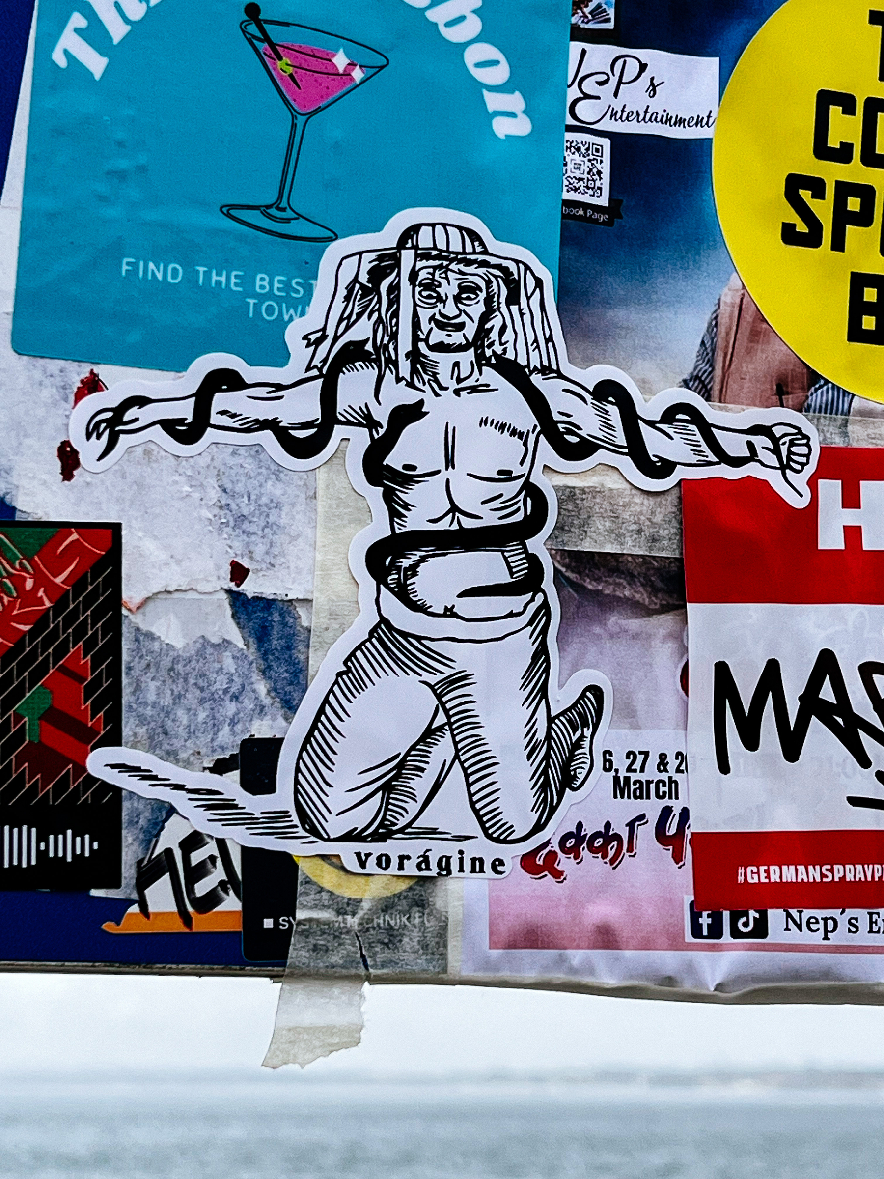 Sticker with a drawing. A man is kneeling, with snakes wrapped around his body. 