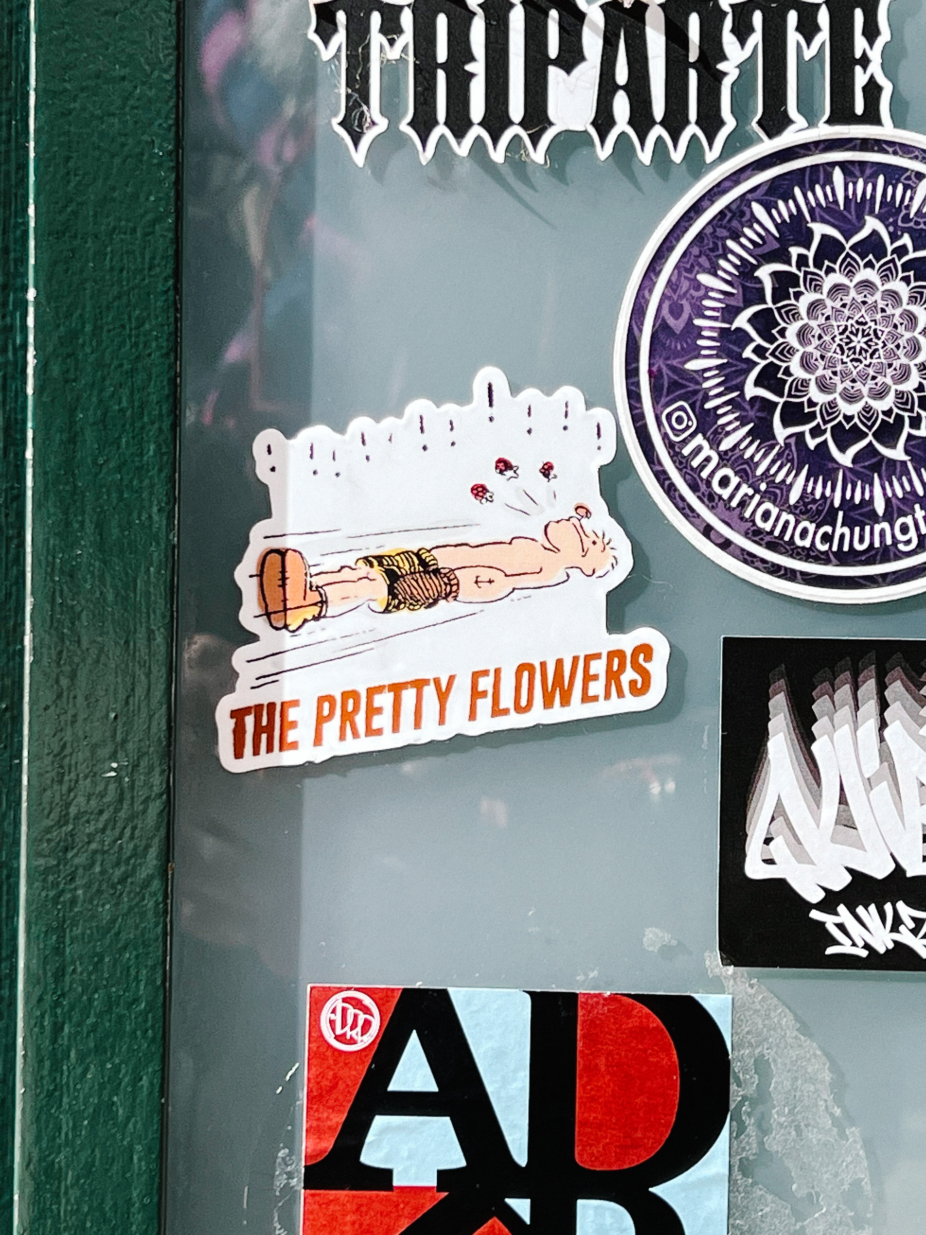 Sticker with Popeye lying down, and the words “the pretty flowers”. 