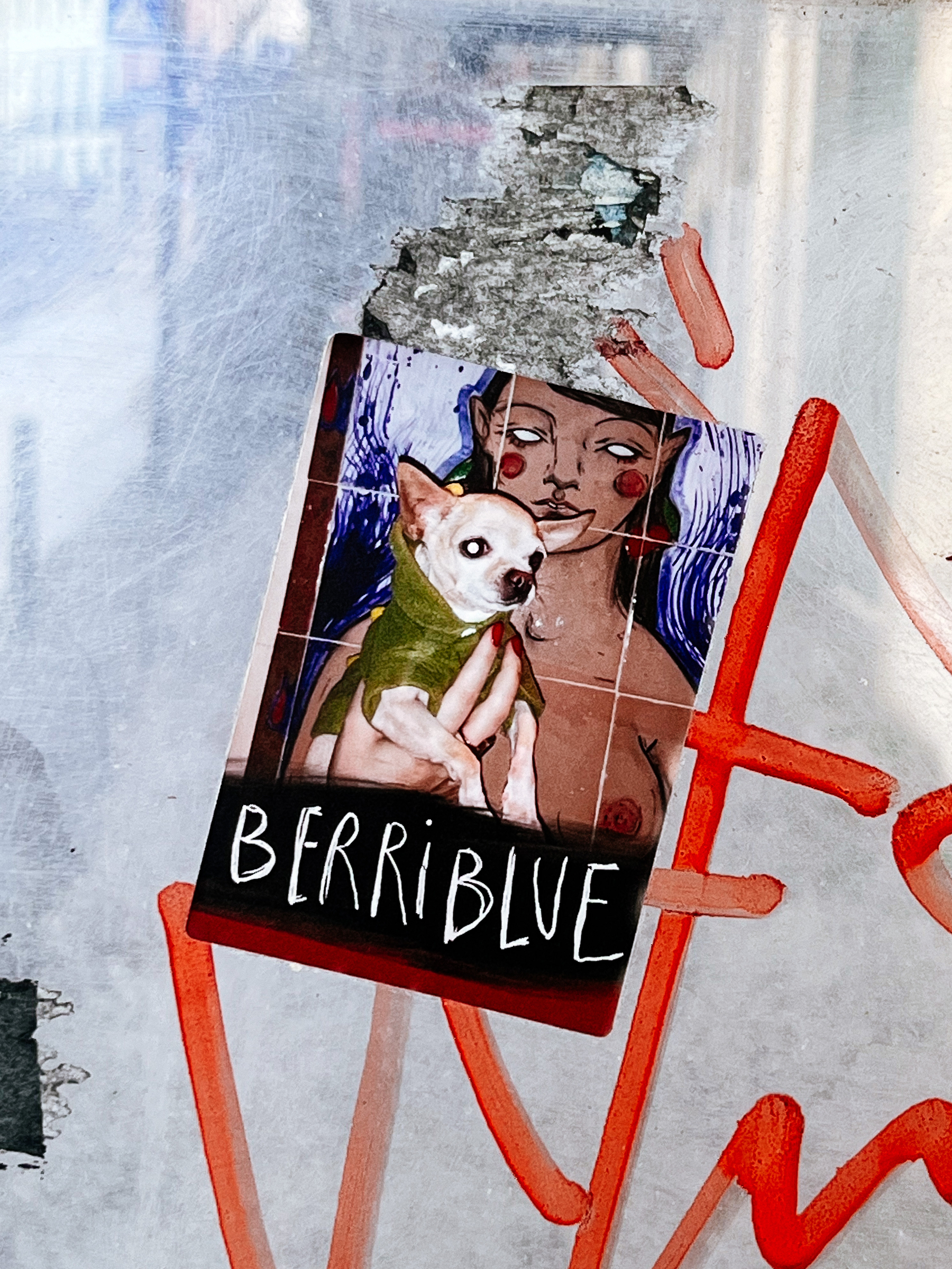 Sticker with &ldquo;Berriblue&rdquo; written on the bottom, and a composite. There&rsquo;s a photo of a chihuahua, being held by a woman. The woman is a drawing though, expect the hand holding the dog. That&rsquo;s real.
