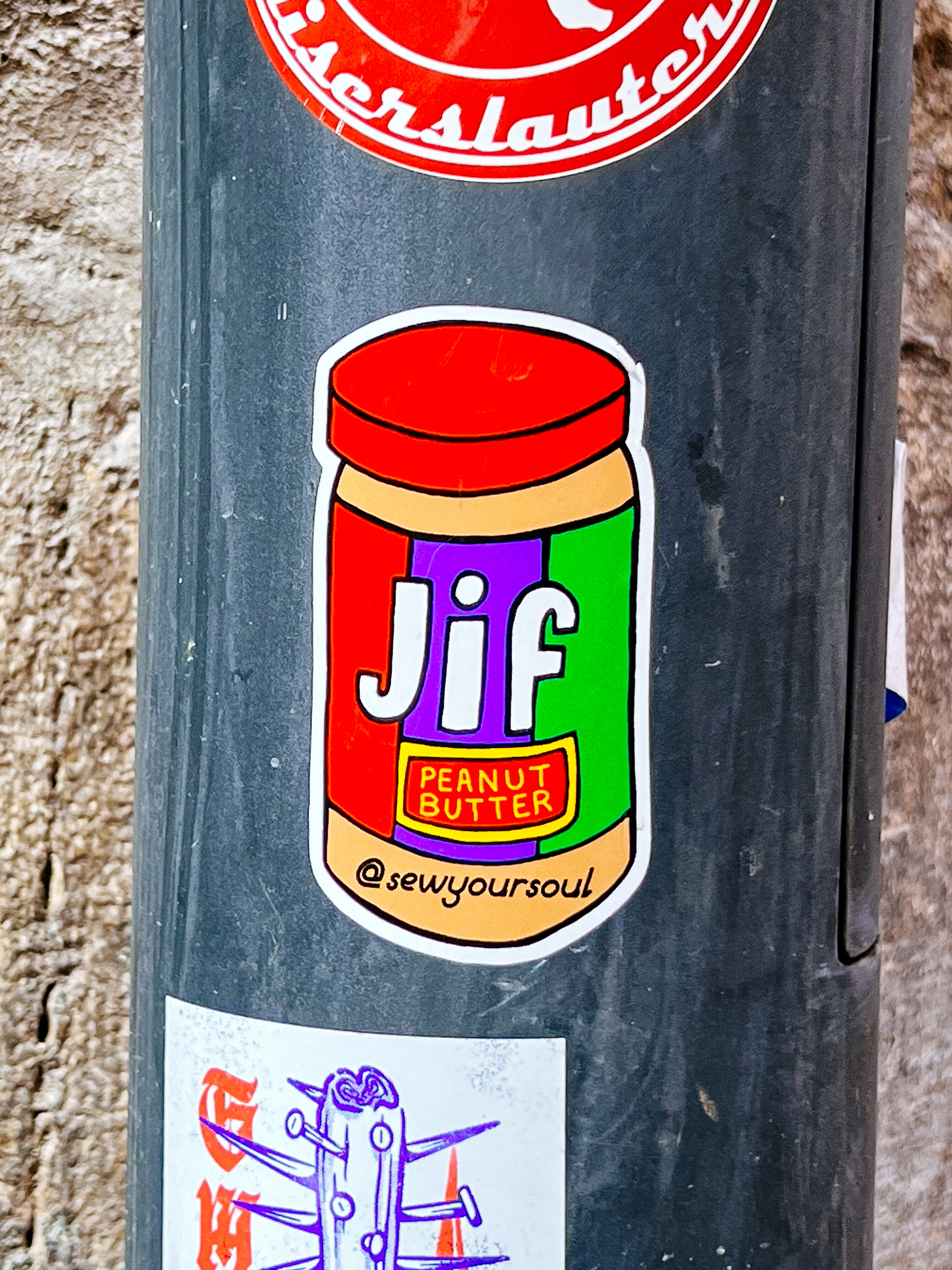 Sticker with a drawing of a very colorful jar of jif, peanut butter. “@sewyoursoul” written in there as well. 