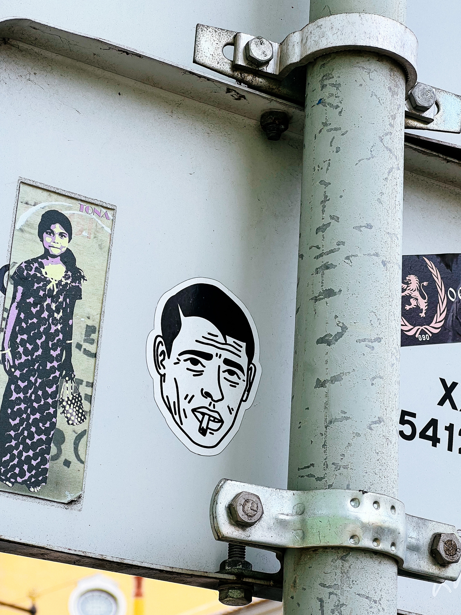 Sticker of a man smoking a cigarette, and another next to it of a young girl. 
