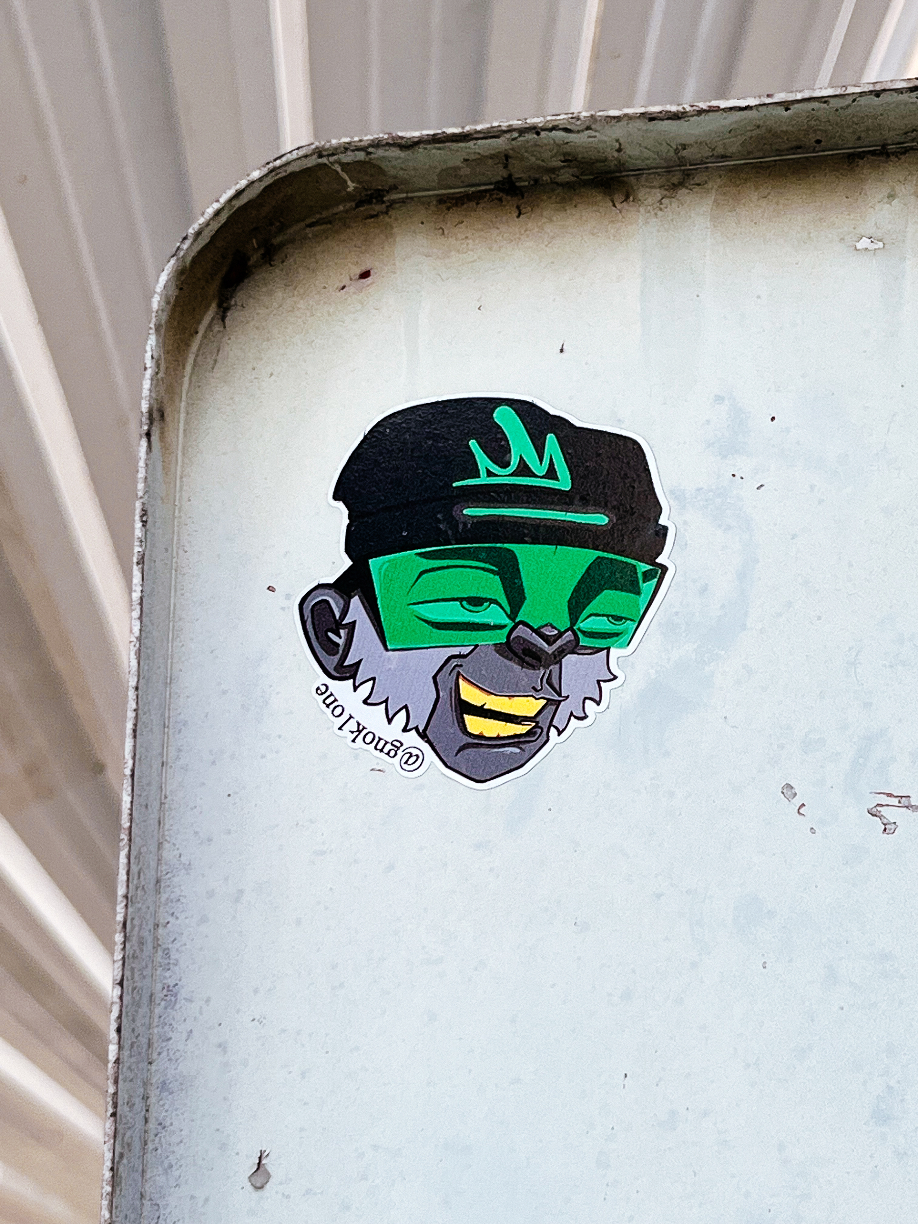 A monkey wearing a beret, and green shades. He looks like he smoked something, and he’s flying high. It’s a sticker, not a real monkey, of course. 