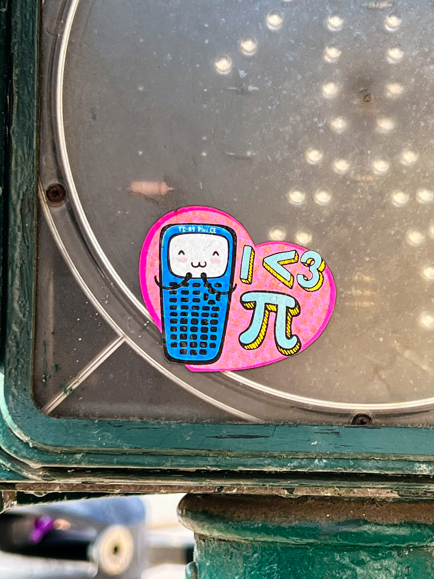 A smiling calculator and &ldquo;I &lt; 3 π&rdquo;, over a pink heart. 