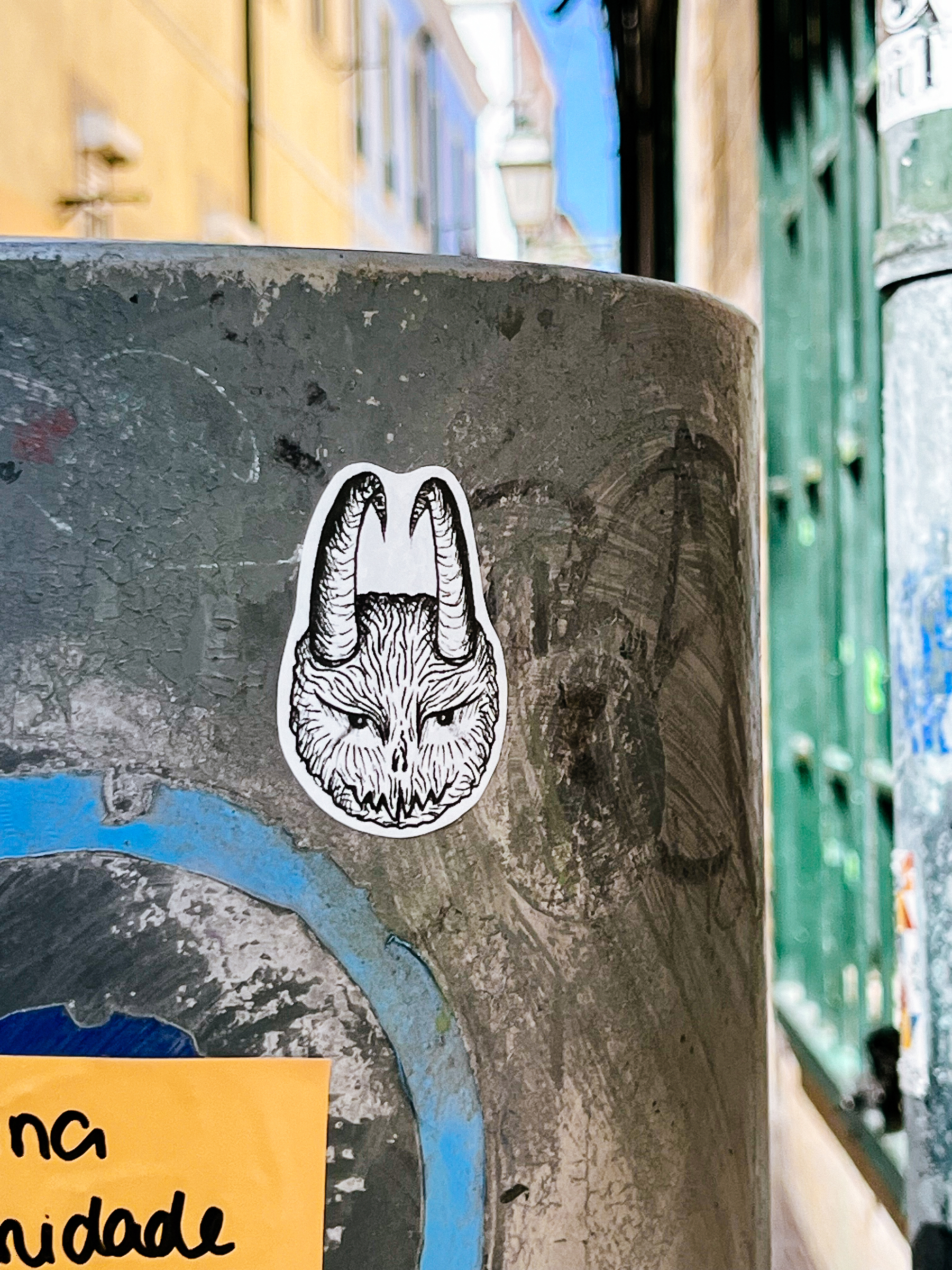 A strange round furry head with horns. Sticker. 