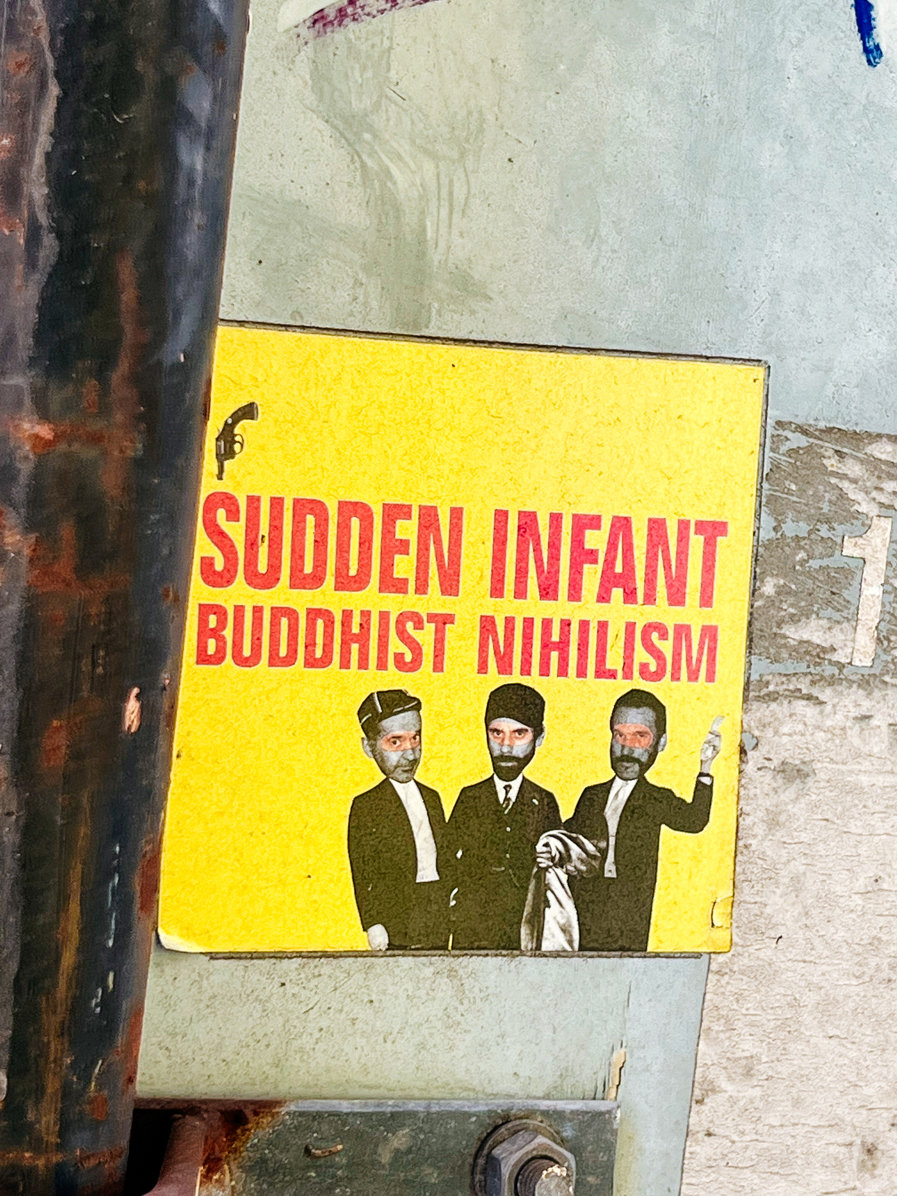 Sticker with “SUDDEN INFANT BUDDHIST NIHILISM”, and three little men. 