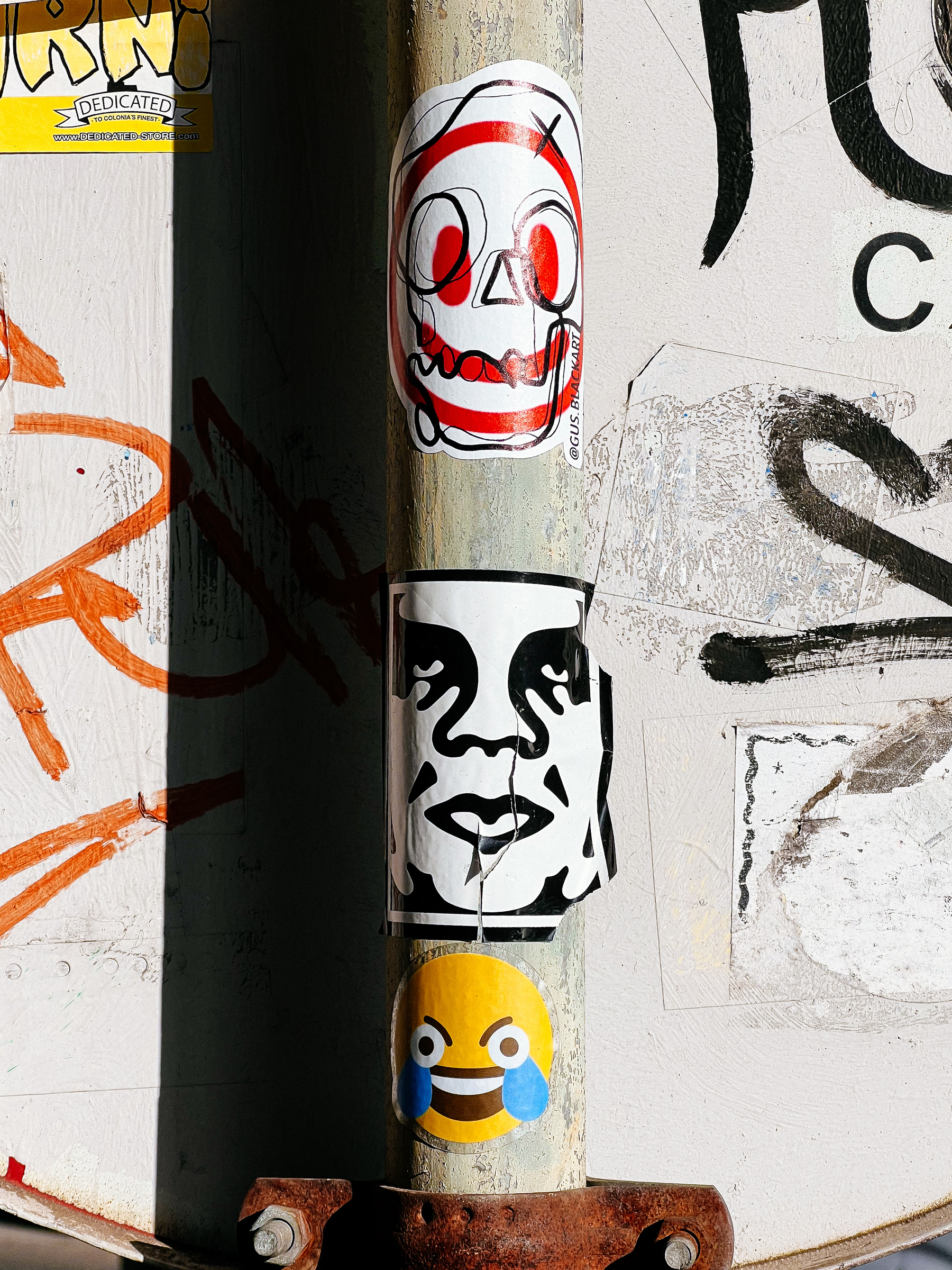 Three stickers on a pole, three different faces. 