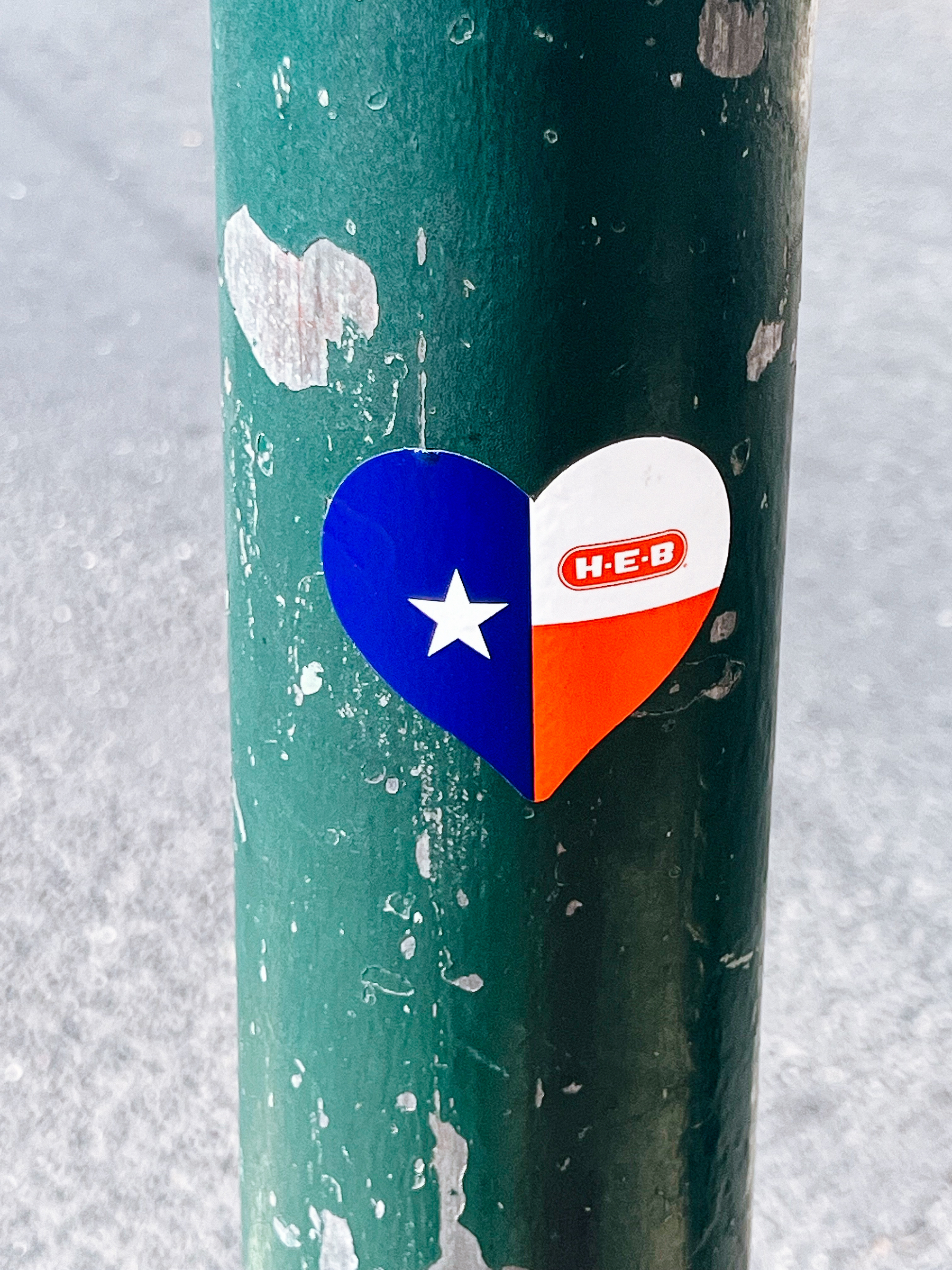 A sticker in the shape of a heart with the Texas flag. 