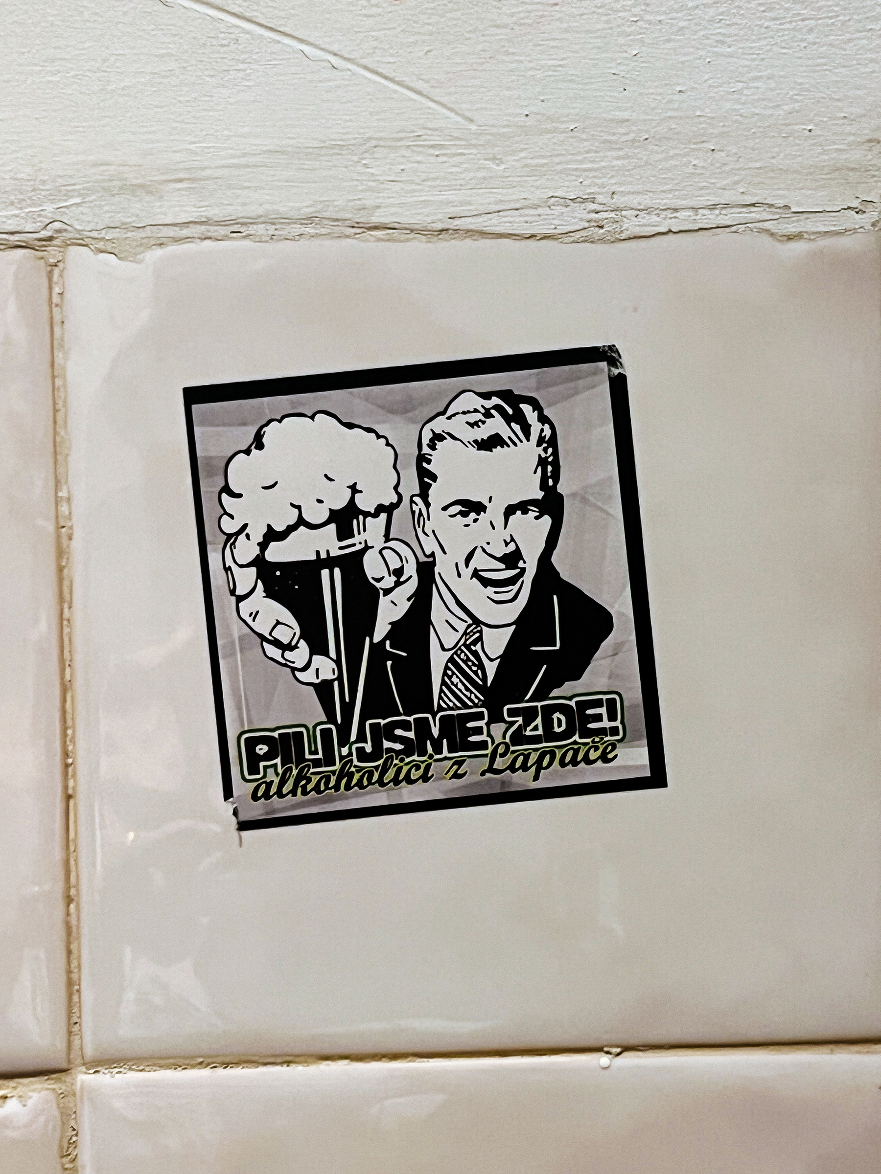 Sticker with a drawing of a man holding a beer to our face. 