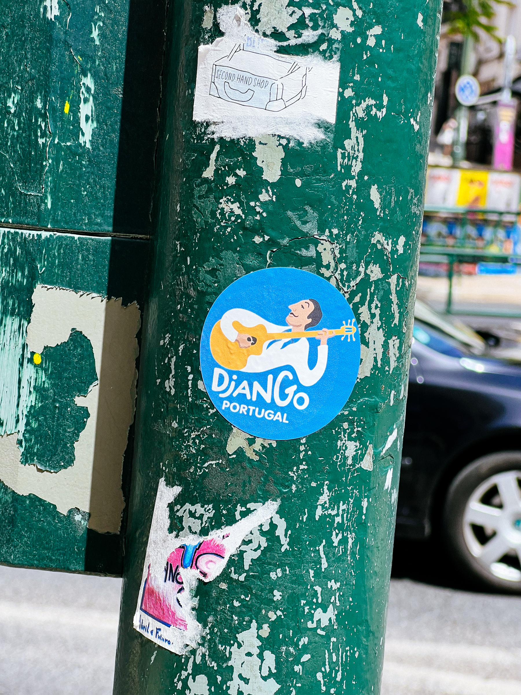 A man playing a guitar, and “Django Portugal”. Drawing, on a sticker. 