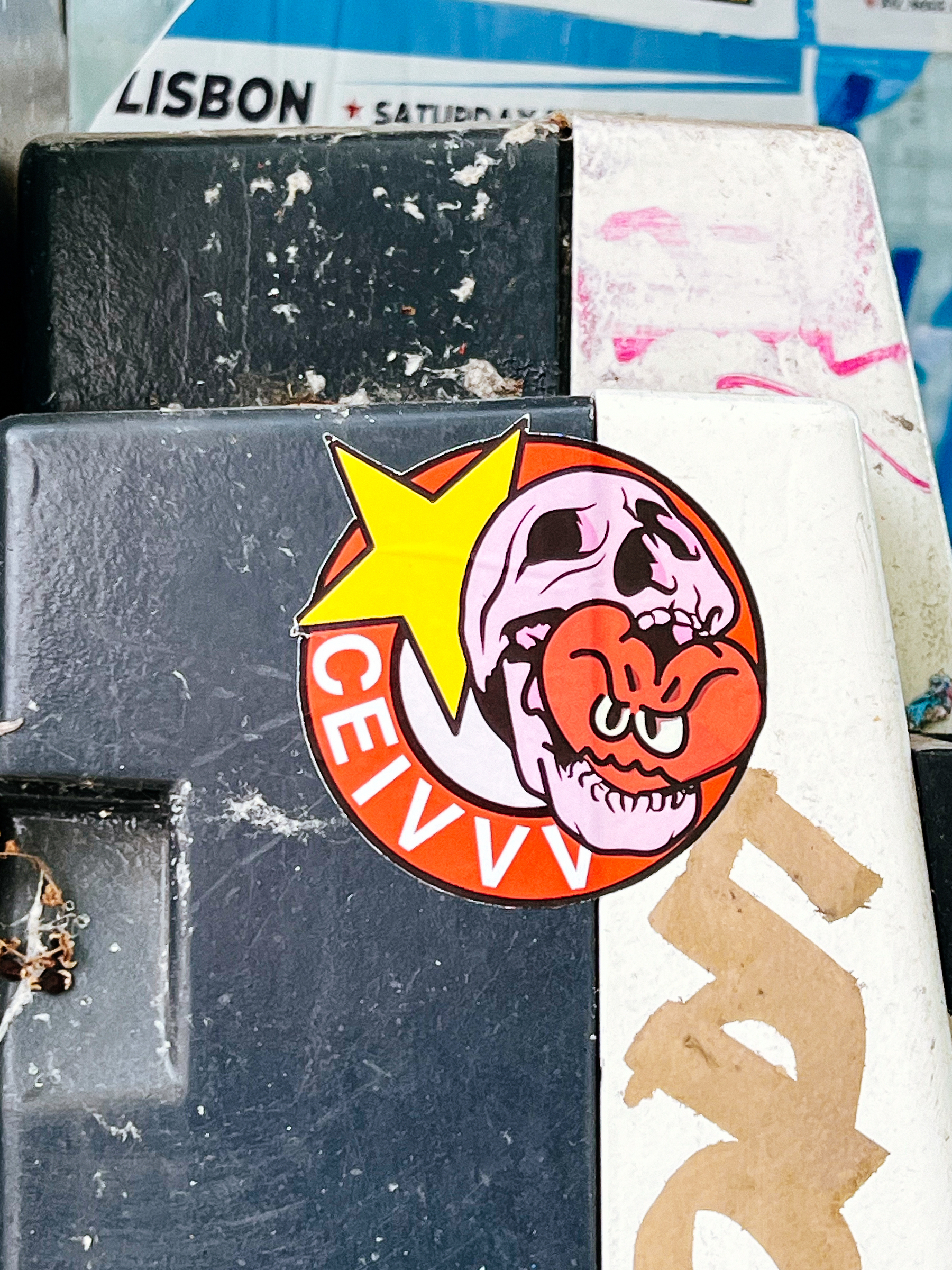 A skull biting a heart, with a star behind them. The characters “CEIVVV”. Sticker. 