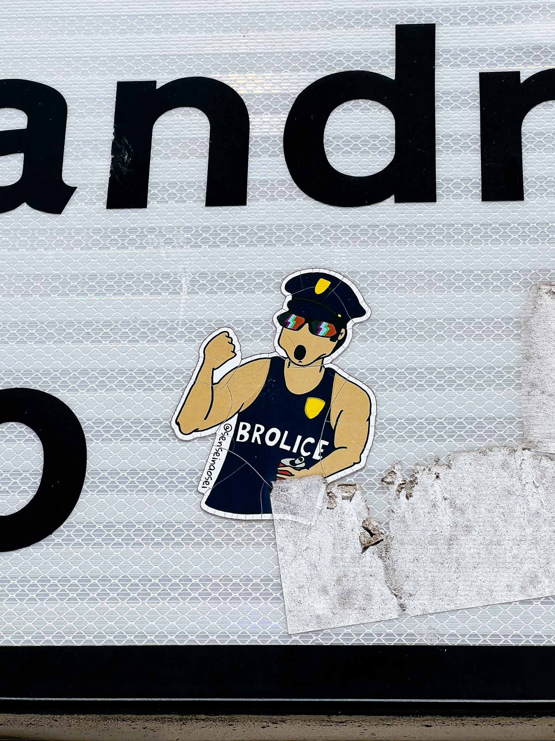 Tank top wearing police officer, with “Brolice” written on the shirt. Sticker. 