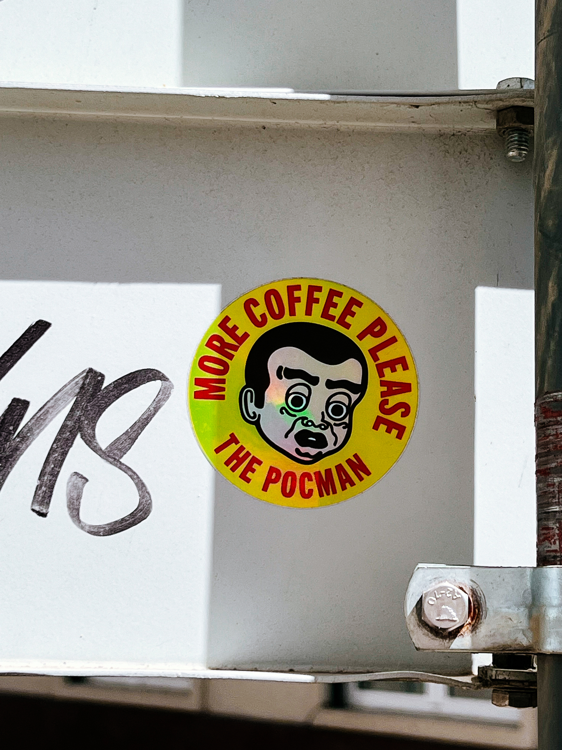 “More coffee please. The Pocman”. And a face. On a sticker. 
